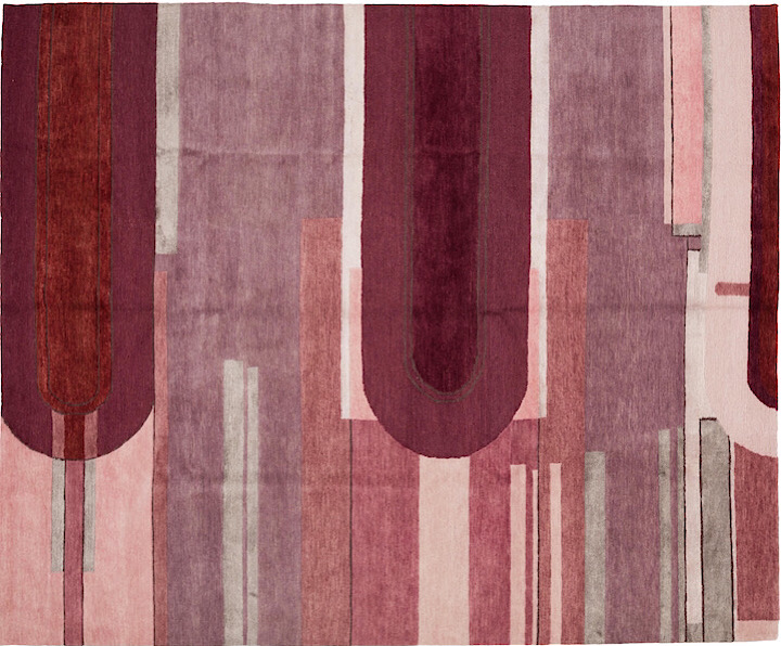 A rug with stripes and a curved pattern in purple, pink, magenta, and grays.